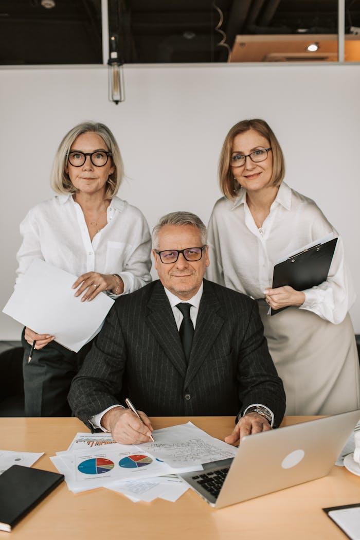 gallery-3 A group of senior business professionals collaborating in an office setting.